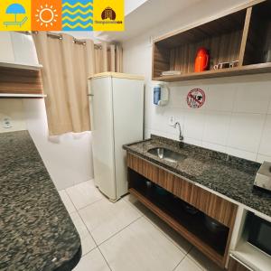 een kleine keuken met een spoelbak en een koelkast bij L'acqua diRoma 1 2 3 4 5 - Temporada CN in Caldas Novas