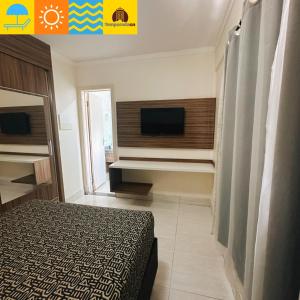 een slaapkamer met een bed en een flatscreen-tv bij L'acqua diRoma 1 2 3 4 5 - Temporada CN in Caldas Novas +6 foto's