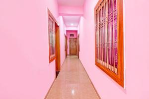 a corridor of a room with pink walls at Hotel O Heaven Inn in Gwalior