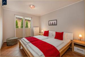 a bedroom with a large bed with red pillows at Tema 2 in Ahlbeck