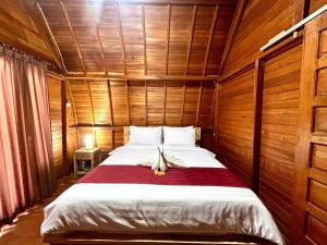 a bedroom with a bed in a wooden room at Arkatama Lumbung Bali in Onggokanbatue