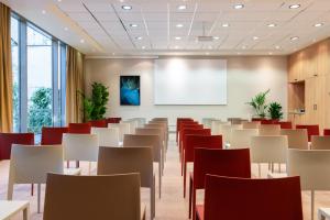 a room with tables and chairs and a projection screen at TRIBE Düsseldorf in Düsseldorf