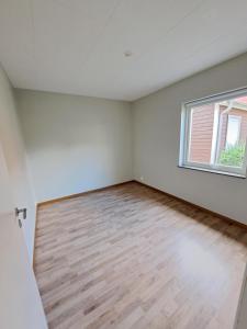 an empty room with a window and a wooden floor at Hallsberg Bostad in Hallsberg