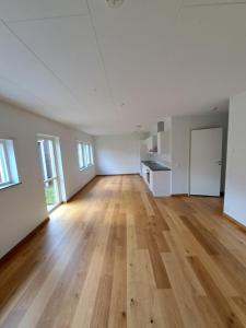 an empty room with a hard wood floor and windows at Hallsberg Bostad in Hallsberg