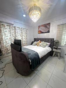 a bedroom with a large bed and a chandelier at Jackson's View in Kwabenya