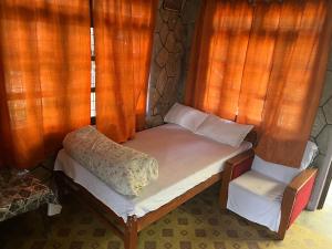 - un petit lit dans une chambre dotée de rideaux orange dans l'établissement The Hotel Orchid & Restaurant, à Kāskī 31 autres photos