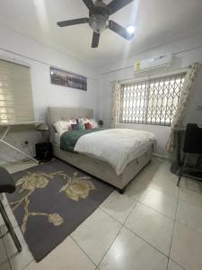 a bedroom with a bed and a ceiling fan at Jackson's View in Kwabenyan +1 photo