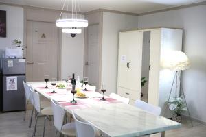 a dining room with a long table and white chairs at Daegu Room new open 4 RoomPrivate Villa in Daegu +79 photos