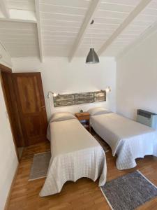 two beds sitting in a room with at Inti Laufquen in San Carlos de Bariloche