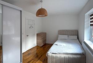 a white bedroom with a bed and a window at Large Double Room in Longbridge +8 photos