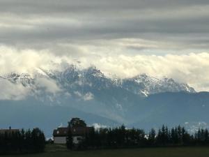 a snow covered mountain range with a house in front at Cabana Dintre Fagi in Poiana Mărului