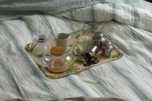 a tray with glasses and other items on a bed at The Doghouse B&B in Bruges