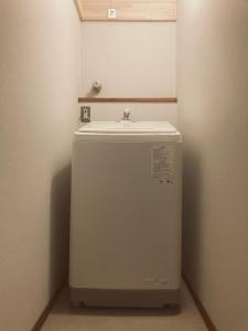 Cette chambre comprend un petit réfrigérateur et un évier. dans l'établissement 森と温もりに包まれる長野飯綱高原の隠れ宿ヴァイオレットハウス, à Nagano