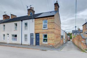an old brick building on the side of a street at Cosy Stamford Retreat 2 Bed House Near Town Centre in Stamford