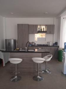 a kitchen with two bar stools and a kitchen counter at Finca el porvenir in Sasaima