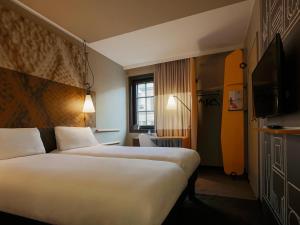 a hotel room with two beds and a television at ibis Hotel Brussels off Grand'Place in Brussels