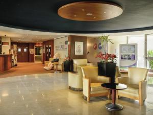 a lobby with a waiting room with yellow chairs at Novotel Porto Gaia in Vila Nova de Gaia +64 photos