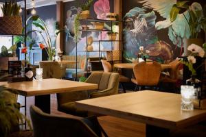 a restaurant with tables and chairs and a mural at Harbour Hub Hotel in Harlingen
