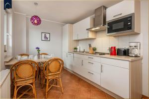 a kitchen with white cabinets and a table and chairs at Tema 5 in Ahlbeck +17 photos