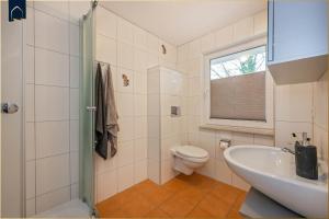 a bathroom with a sink and a toilet and a window at Tema 5 in Ahlbeck +19 photos