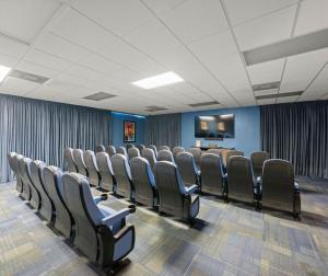 奥兰多Magic Tree Resort的配有椅子和平板电视的会议室