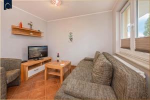 a living room with a couch and a tv at Tema 13 in Ahlbeck