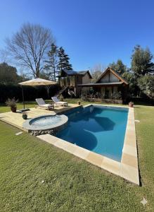 a large swimming pool in front of a house at Cabaña Soñada - Piscina - Jacuzzi in Sierra de los Padres