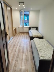 Camera con 2 letti e pavimento in legno. di Mieszkanie Pracownicze Siemianowice Śląskie 15 min od Spodka a Siemianowice Śląskie
