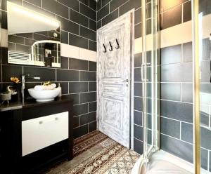 a bathroom with a shower and a sink and a door at Le Cocon Céleste - Appartement d'Exception - Vue sur les Alpes - Centre-Ville - Gare à 1 min in Valence