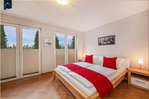 a bedroom with a large bed with red pillows at Tema 14 in Ahlbeck