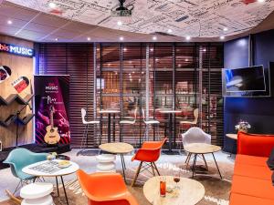 a room with tables and chairs and a tv at Hotel ibis Porto Gaia in Vila Nova de Gaia