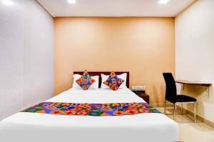 a bedroom with a bed and a desk and a chair at FabHotel Gokul Residency in kolkata
