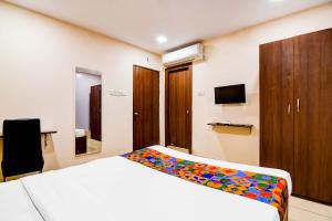 a hotel room with a bed and a tv at FabHotel Gokul Residency in kolkata