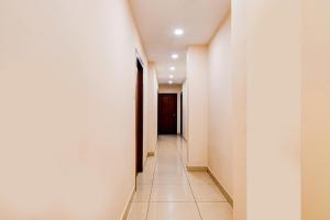 a hallway with white walls and a black door at FabHotel Gokul Residency in kolkata +24 photos