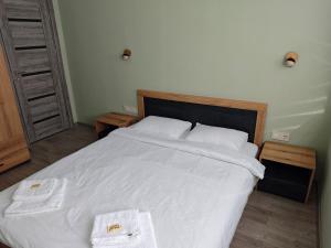 a bedroom with a large white bed with towels on it at Ваканционен апартамент in Tryavna