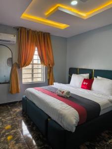 ein Schlafzimmer mit einem großen Bett in einem Zimmer in der Unterkunft Ivy Hotel Epe in Poka