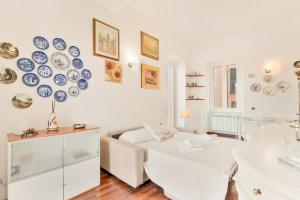 a white living room with blue plates on the wall at La Loggia del Delfino 5 Terre Sea View AC in Lerici