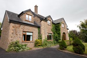 a brick house with a black roof at Drumbo Lodge Cavan in Cavan
