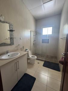 a bathroom with a sink and a toilet and a shower at Your Oasis in Kigali in Kigali +35 photos