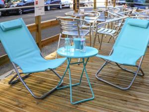 2 sillas azules y una mesa en el patio en ibis Nantes Centre Tour Bretagne, en Nantes