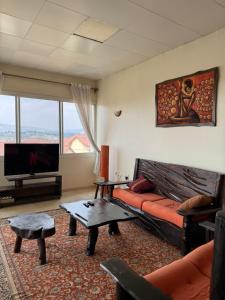 a living room with a couch and a flat screen tv at Your Oasis in Kigali in Kigali