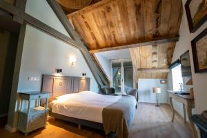 sypialnia z dużym łóżkiem i drewnianym sufitem w obiekcie Hof van Kleeberg w mieście Mechelen