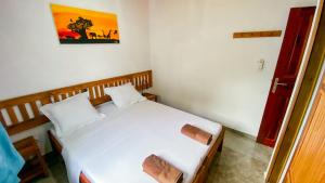 a bedroom with a white bed in a room at Jardin Fleuri de Lety in Nosy Be +16 photos