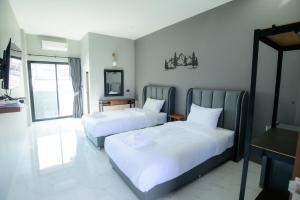 a hotel room with two beds and a mirror at The Breezy Hotel in Muaklek +27 photos