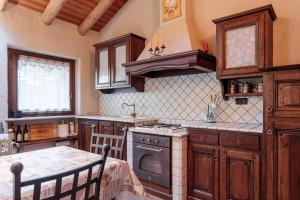 Una cocina con gabinetes de madera y un horno de estufa. en Chalet L'École, en Auri Grande 24 fotos más