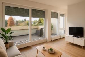 ein Wohnzimmer mit großen Fenstern und einem TV in der Unterkunft Eastside Apartment Karlsruhe in Karlsruhe