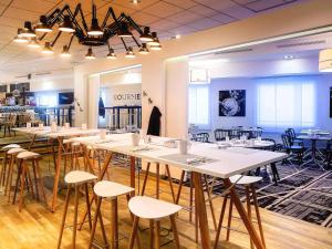 a room with tables and chairs in a store at Novotel Paris Rueil Malmaison in Rueil-Malmaison +198 photos