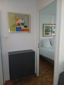 イエールにあるPied à terre - Port de Hyèresのベッドと壁に絵が飾られた寝室