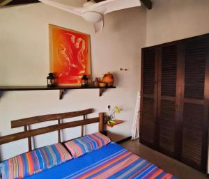 een slaapkamer met een bed en een schilderij aan de muur bij Ibiscus Penthouse in Santa Maria