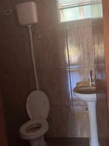 a bathroom with a toilet and a sink at Rancho KurtMel in Coxim +13 photos